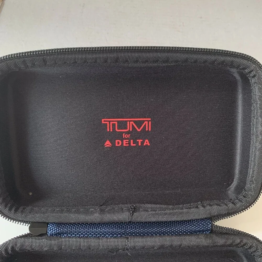 The product is a navy blue hard case amenity kit bag by TUMI for Delta Airlines.